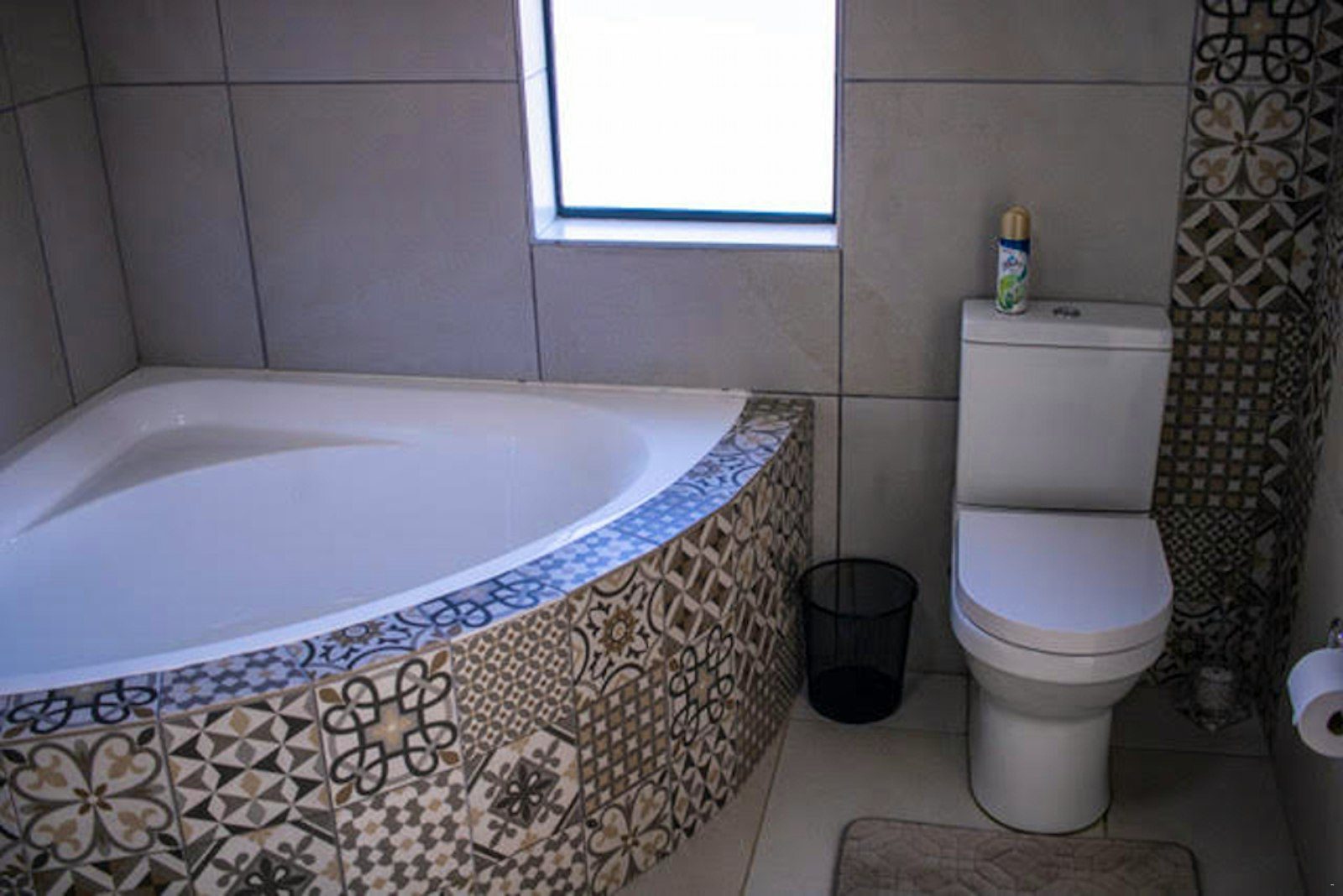Corner bath with patterned tiles