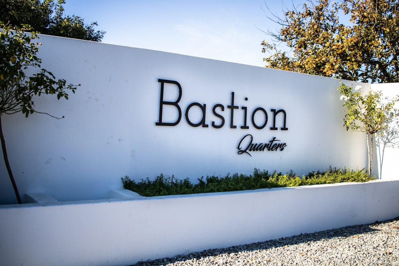 The Bastion Quarters entrance sign on a white wall